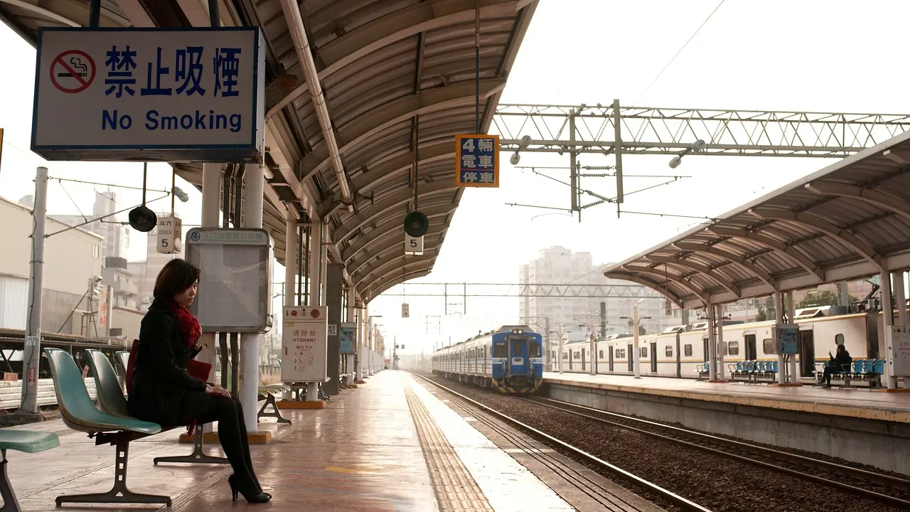 Andén de una estación de tren con viajeros esperando